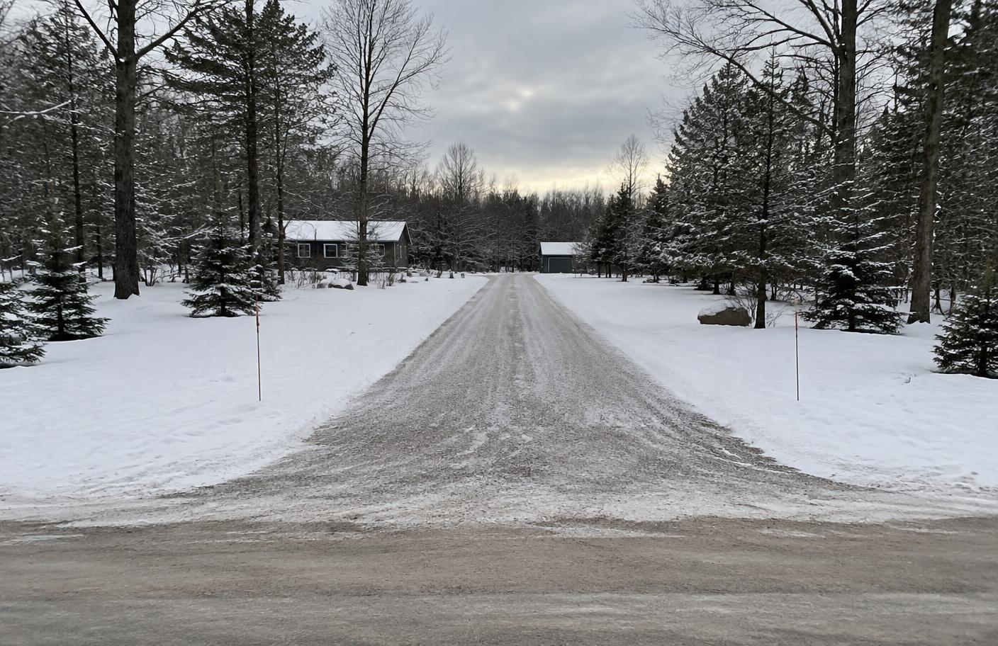 Snowblown cottage lane with full width, open sightlines and snow dispersed away from the edges.
